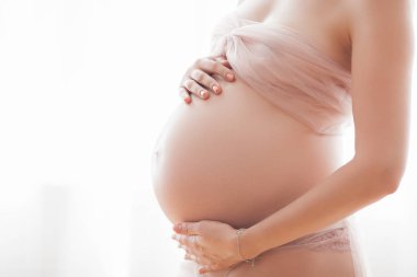 Pegnant kadının yakın çekim resmi. Tanınmaz bir beklenti. Göbek closeup.