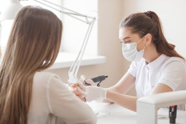 Manikürcü kuaförde manikür yapıyor. Usta servising müşterisi. Çivi bakım prosedürü.