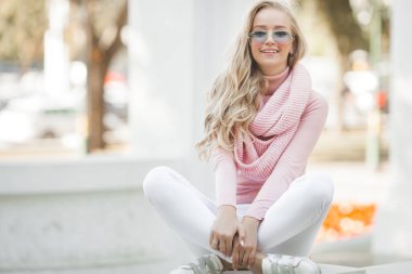 Çekici, genç, sarışın kadın portresi. Sonbahar güneşinin arka planında açık havada bir kadın. Sonbaharda neşeli bir kadın portresi..