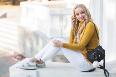 Çekici, genç, sarışın kadın portresi. Sonbahar güneşinin arka planında açık havada bir kadın. Sonbaharda neşeli bir kadın portresi..