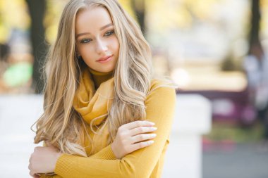 Çekici, genç, sarışın kadın portresi. Sonbahar güneşinin arka planında açık havada bir kadın. Sonbaharda neşeli bir kadın portresi..