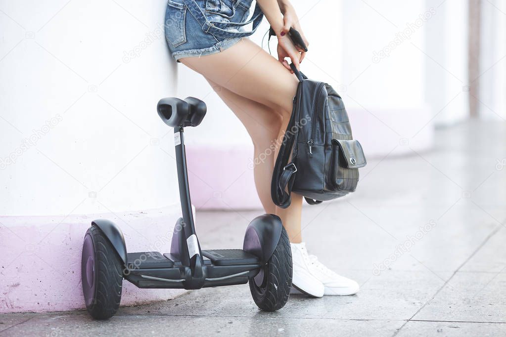 Attractive young woman outdoors riding a segway. Pretty female on scooter. Modern youth.