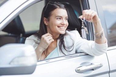 Kadının elinde yeni arabasının anahtarları var..