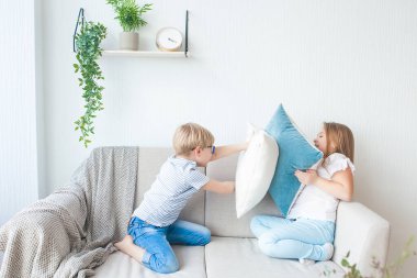 Şirin çocuklar içeride eğleniyor. Yastık savaşı. Çocuklar birlikte oynuyor..