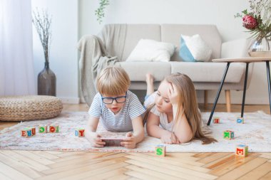 Akıllı telefondan oynayan çocuklar. İçeride aletleri olan çocuklar..