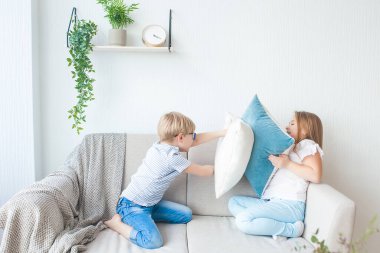 Şirin çocuklar içeride eğleniyor. Yastık savaşı. Çocuklar birlikte oynuyor..