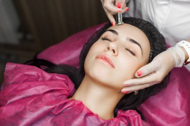 Mezoterapi. Genç doktor yüz gerdirme yöntemi uyguluyor. Dermatolog beni beceriyor..