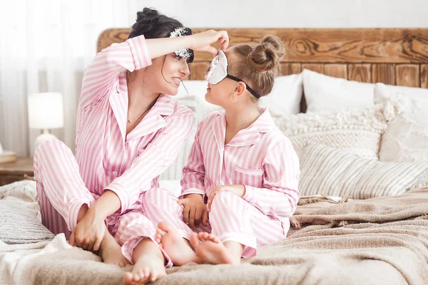 若いですアクティブ母と彼女の小さな娘あります楽しいです一緒に家にザベッドルームでパジャマを着て — ストック写真