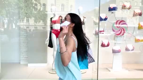 若いです魅力的な女性とともにショッピングバッグ近くザショーケース — ストック動画