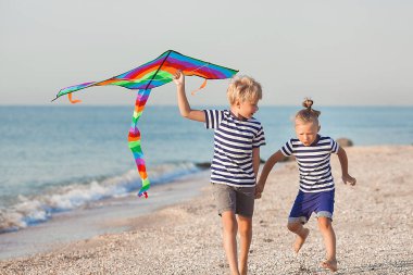 Çocuklar deniz kenarında eğleniyor.