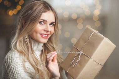 Noel arkaplanındaki çekici sarışın genç kadının yakın plan portresi.