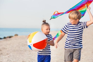 Çocuklar deniz kenarında eğleniyor.