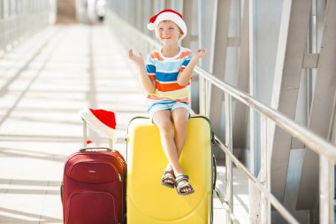 Noel şapkalı mutlu çocuk havaalanında.