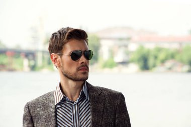 Şık erkek güneş gözlüğü ve trendy ceket şehir sokak poz