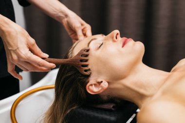 Kadın, sakin bir spa ortamında rahat bir şekilde uzanan, rahatlamayı, sağlığını ve güzellik rutinlerinde kendine bakmanın önemini vurgulayan, rahatlatıcı bir yüz masajından hoşlanır.