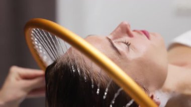 İçerideki hafif duş akıntısı altında dinlenen kadın.