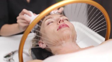 Rahatlamış bir kadın evde spa tedavisi görüyor.