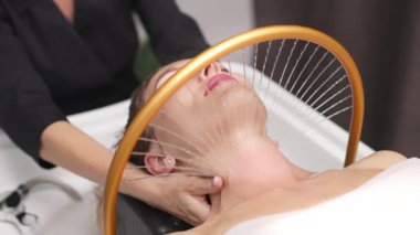 Kadın spa tedavisi sırasında boyun masajı yaptırıyor.