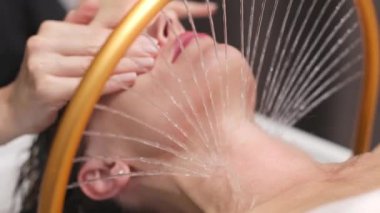 Rahatlamış kadın hafif yüz spreyi tedavisi görüyor.