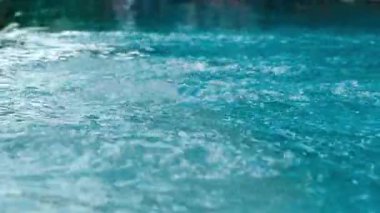 Durgun mavi su yüzeyine damlayan yağmur damlaları