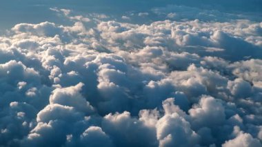 Mavi gökyüzünde süzülen tüylü beyaz bulutlar