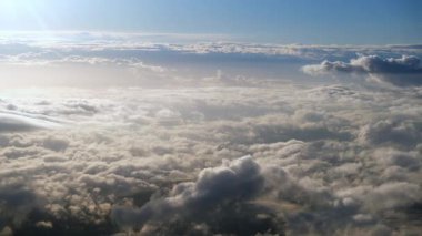 Mavi gökyüzünde süzülen tüylü beyaz bulutlar