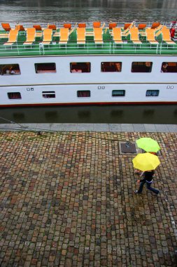 şemsiye ile pier üzerine parlak sarı şemsiye insanlar bir Arnavut kaldırımlı set Ortaçağ şehir yürüyüş bir çift yürüyüş