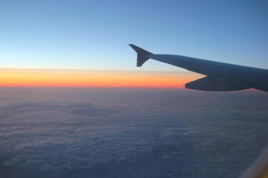 Uçak penceresinden görüş sıfır yerçekimi düşüncesi dinlenme zamanı uçak yolculuğu meditasyon günbatımının bulutlar yükseklik kanadı yansımaları