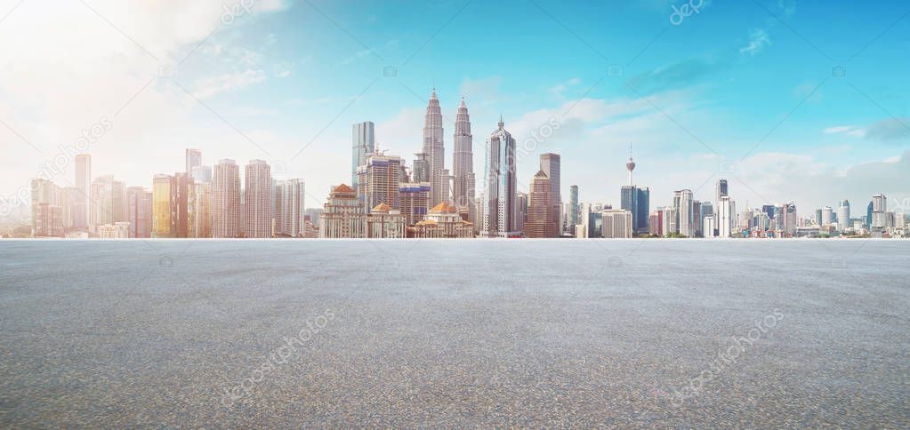 Empty asphalt road with modern city skyline .