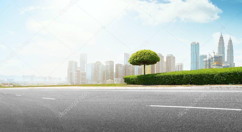 Empty asphalt road with modern city skyline .