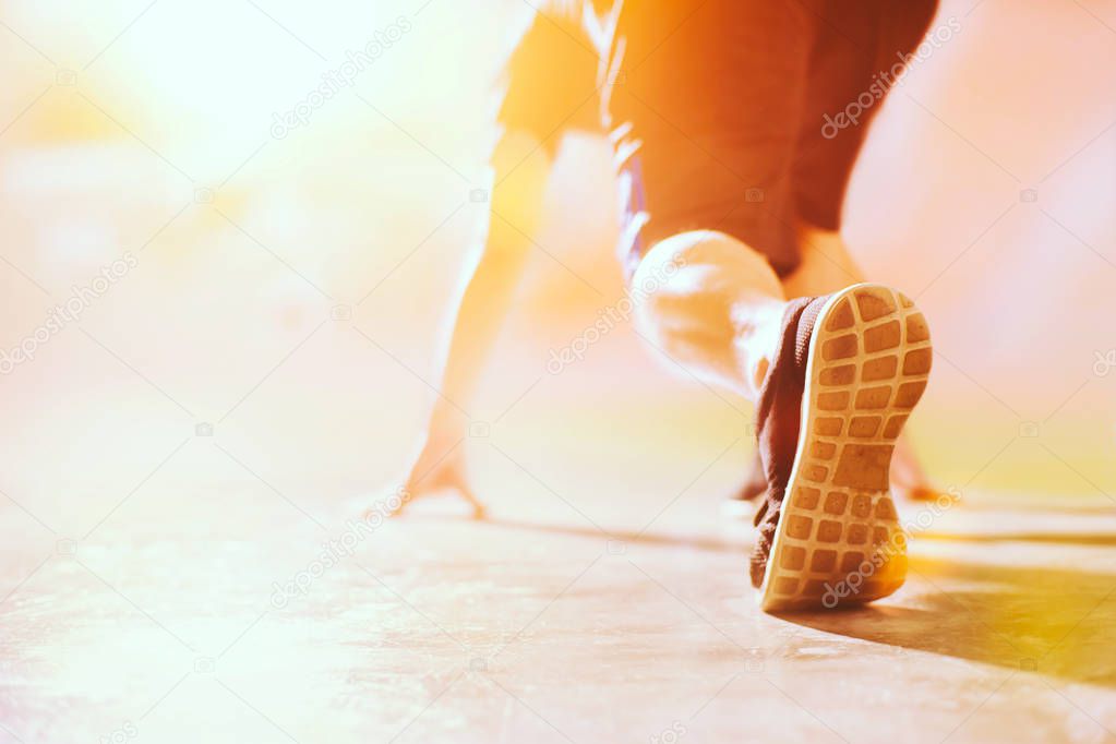 Athlete in running start pose on street with copy space, Selected focus on shoe with blurry background