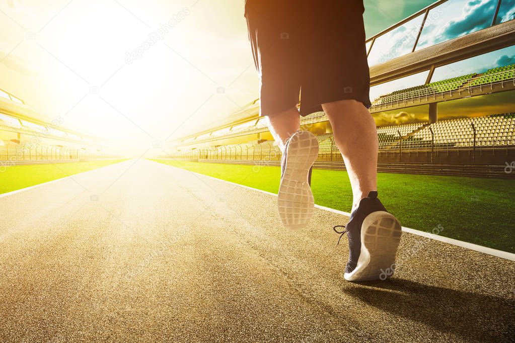 runner legs run on stadium at sunny day, close-up 