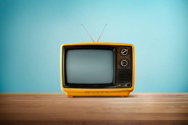 Sarı turuncu renk eski vintage retro televizyon ahşap masa nane mavi arka plan ile