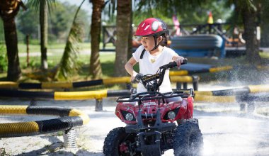 Küçük kız yarış pisti ATV quad bisiklet sürme .