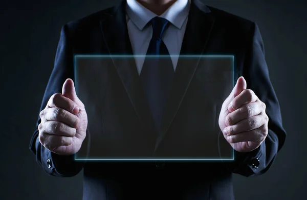 Businessman holding a clear glass empty virtual screen template, notice purpose and information using ideal concept