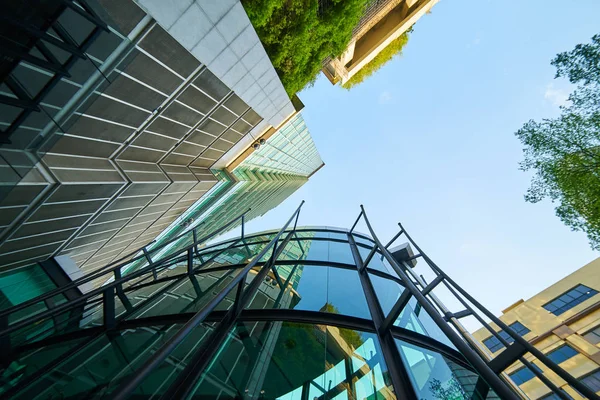 低角度拍摄的现代玻璃建筑和绿色的晴朗的天空背景 — 图库照片
