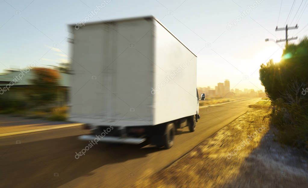 Truck traveling on road at sunrise - speed and delivery concept.