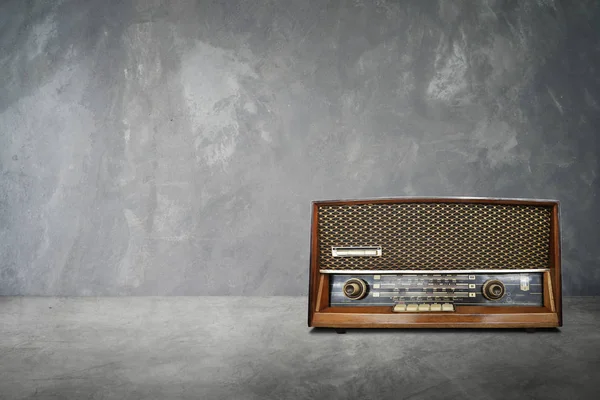 Old vintage retro broadcast radio on cement table with cement background