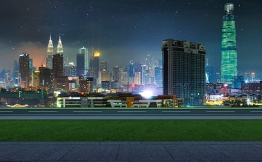 Yan görünümü asfalt yol ile geçit ve yeşil çimenlerin üzerinde gece, Kuala Lumpur şehir