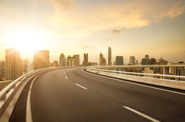 Curvy flyover highway moving forward road with Bangkok cityscape sunrise scene view . motion blur effect apply