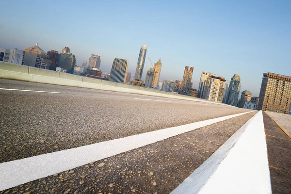 Low angle straight highway road with Bangkok cityscape morning scene view