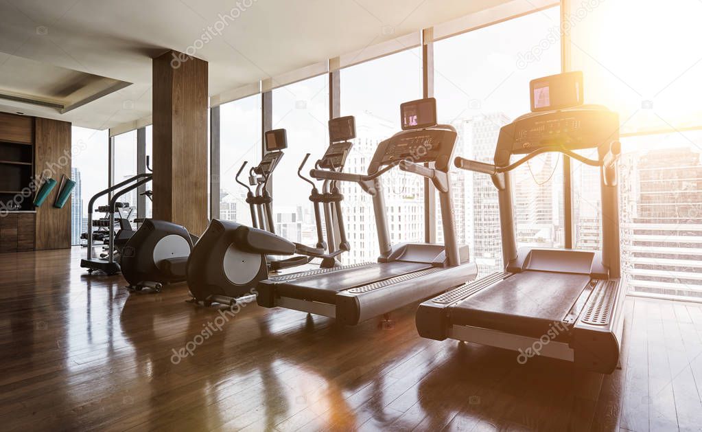 Modern gym room fitness center with set of treadmills staying in line , morning sunrise  scene .