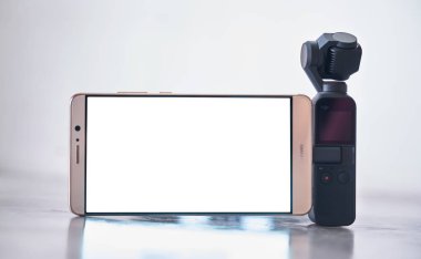 Kuala Lumpur, Malezya - Ocak 9,2019: yeni yayımlanan ile DJI indeks işlem Osmo cep beyaz arka plan üzerinde akıllı telefon ile. Osmo cep ilk en küçük 3-eksenli stabilize el video kamera olduğunu .