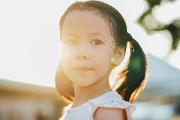 日没の間に公園でディンプルと小さなアジアの女の子の肖像画を閉じます — ストック写真