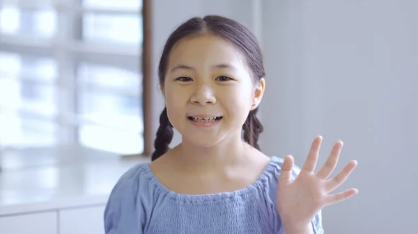 Aranyos Ázsiai Kislány Mosolyog Integet Kezét Nézi Kamera Otthon — Stock Fotó