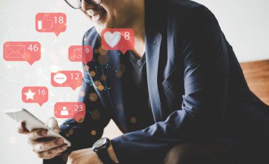 Sosyal medya simgesi olan akıllı telefon kullanan bir işadamı. Sosyal medya pazarlama kavramı.