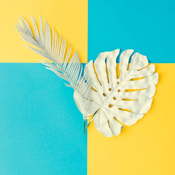 白色被绘的热带和棕榈叶子在黄色和蓝色背景 概念艺术 — 图库照片