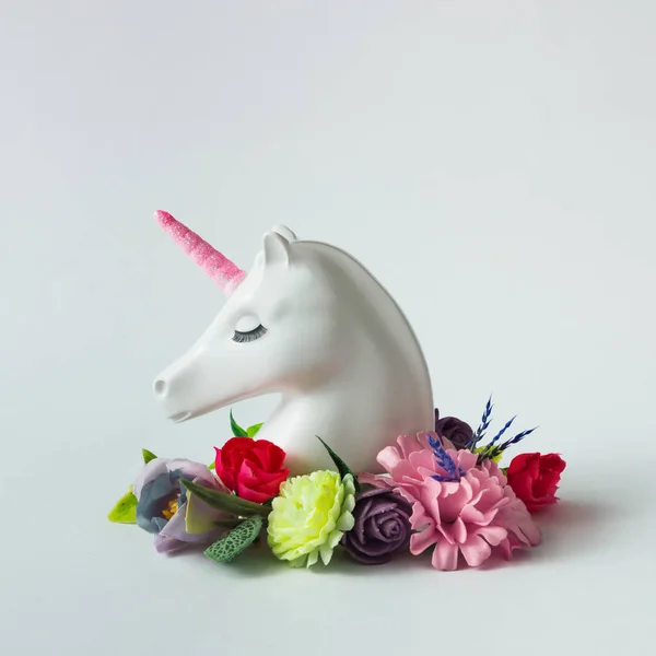 白色彩绘独角兽头与五颜六色的花朵和树叶在明亮的白色背景 最小的艺术幻想概念 夏日童话 — 图库照片