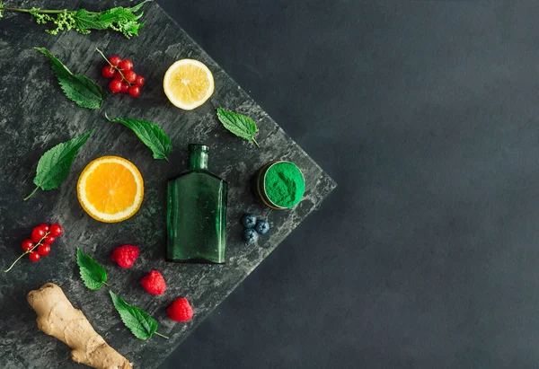 Creative food layout with fruits, vegetables and leaves on dark stone table background. Minimal healthy drink concept. Flat lay.