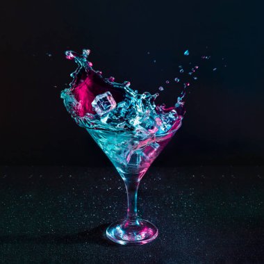 Martini kokteyl içki splash buz küpleri neon yanardöner pembe ve mavi renklerde, en az gece parti yaşam kavramı ile